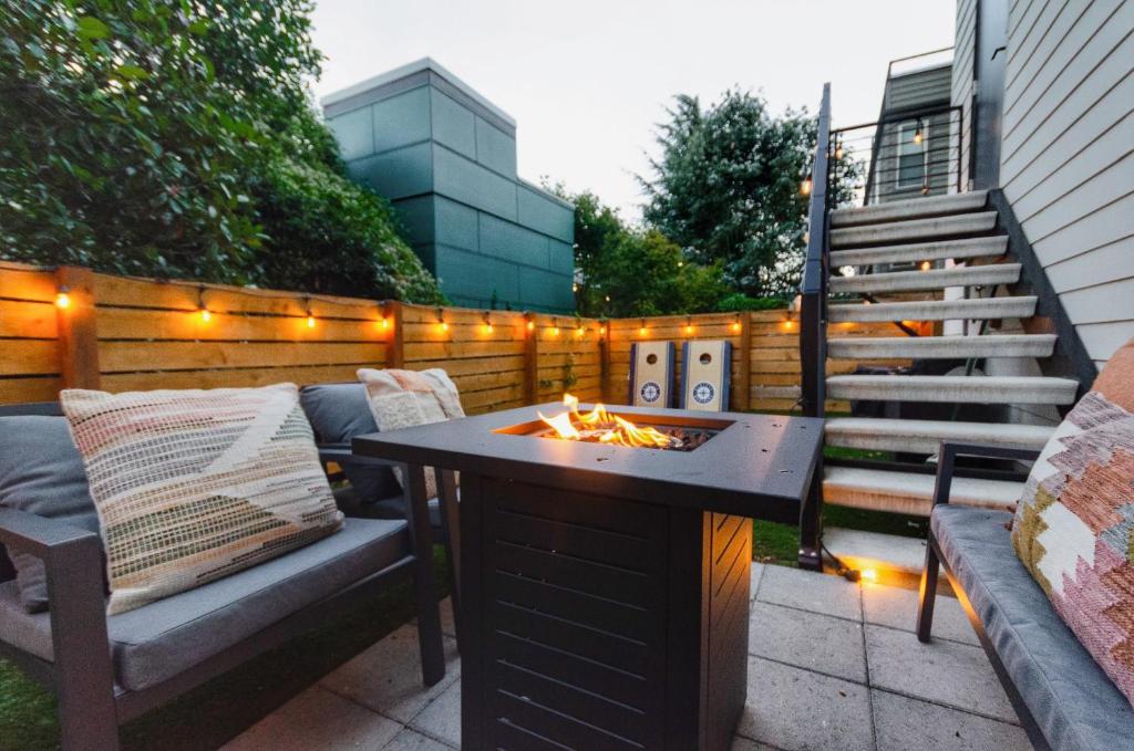 a patio with a fire pit and a bench and stairs at Travelers Dream, Walk to Space Needle, Firepit, cornhole in Seattle
