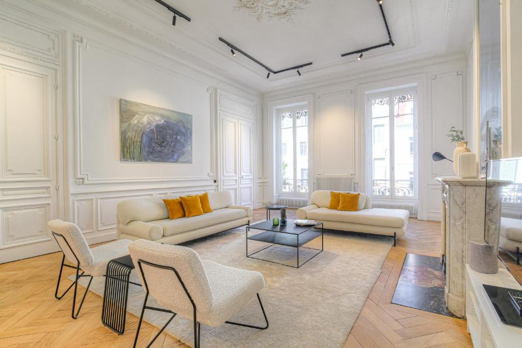 Una sala de estar con dos sofás y una mesa. en Appartement d'exception Lyon 6e, en Fourvière