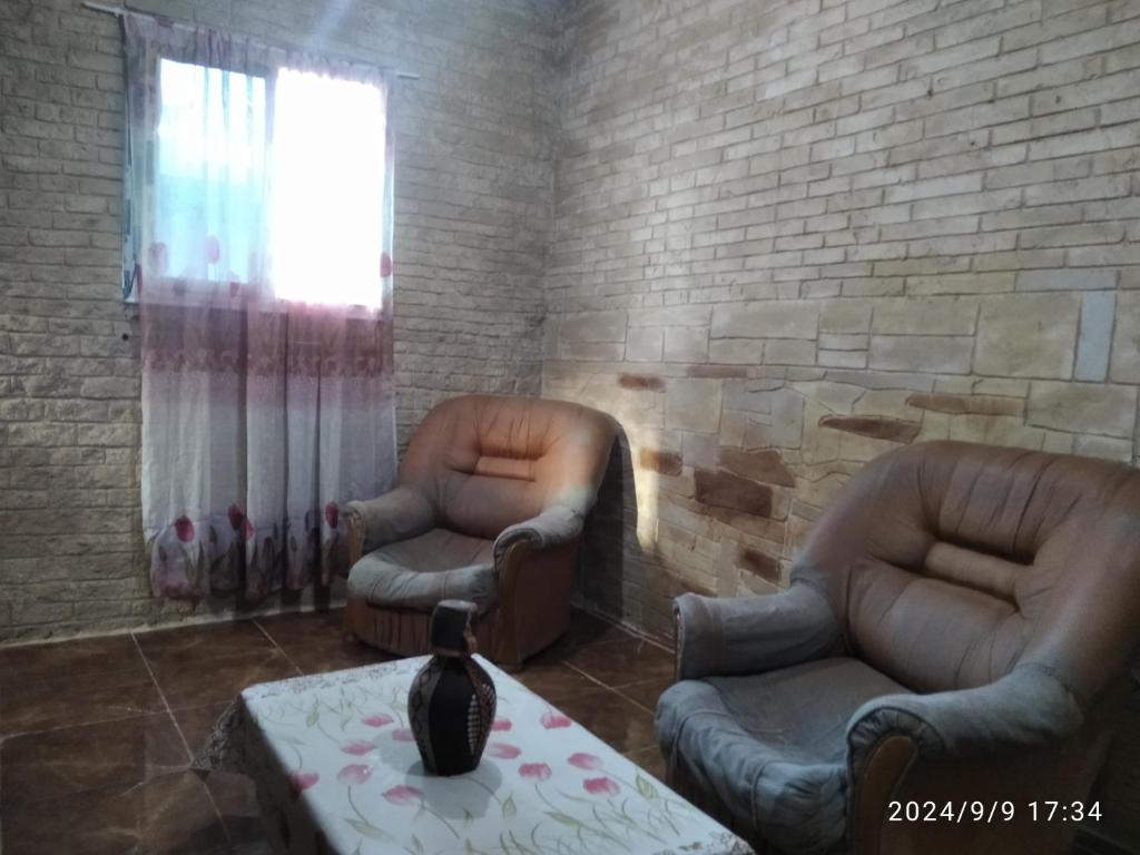 a room with two chairs and a table and a window at Studio peirechahin in Tipaza