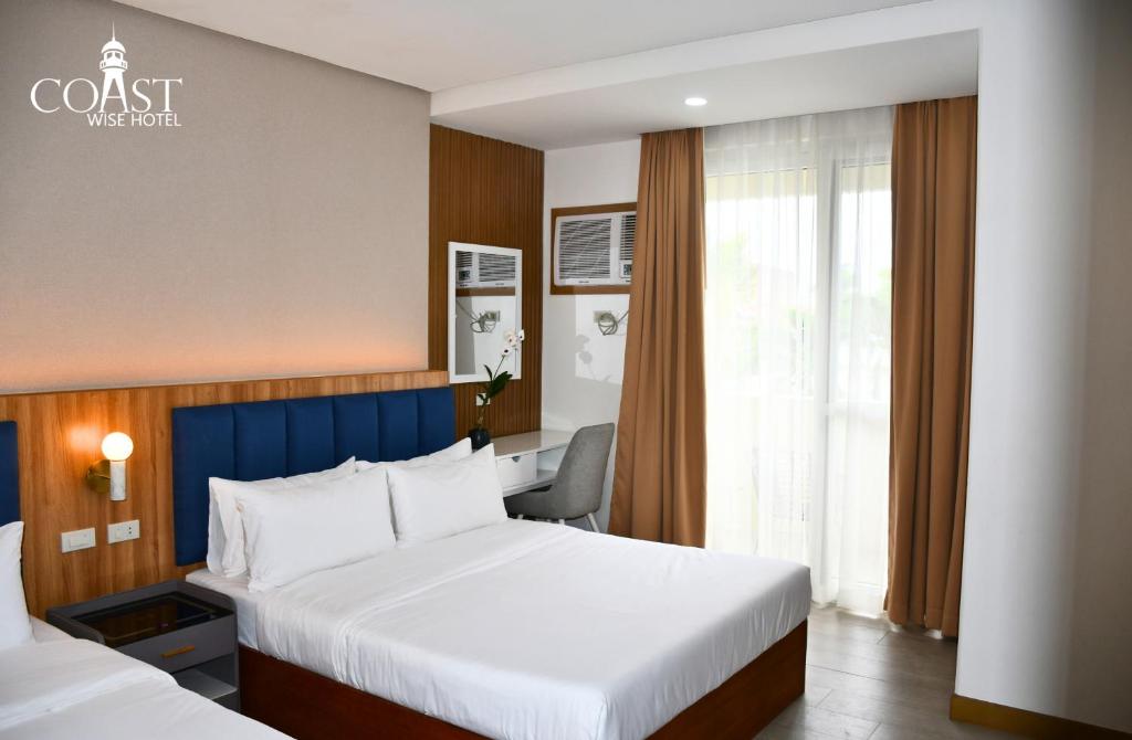 Postel nebo postele na pokoji v ubytování Coast Wise Hotel Dumaguete