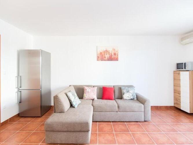 Una sala de estar con un sofá y un refrigerador. en Apartment Budimir - Two Bedroom Apartment with Balcony, en Supetar