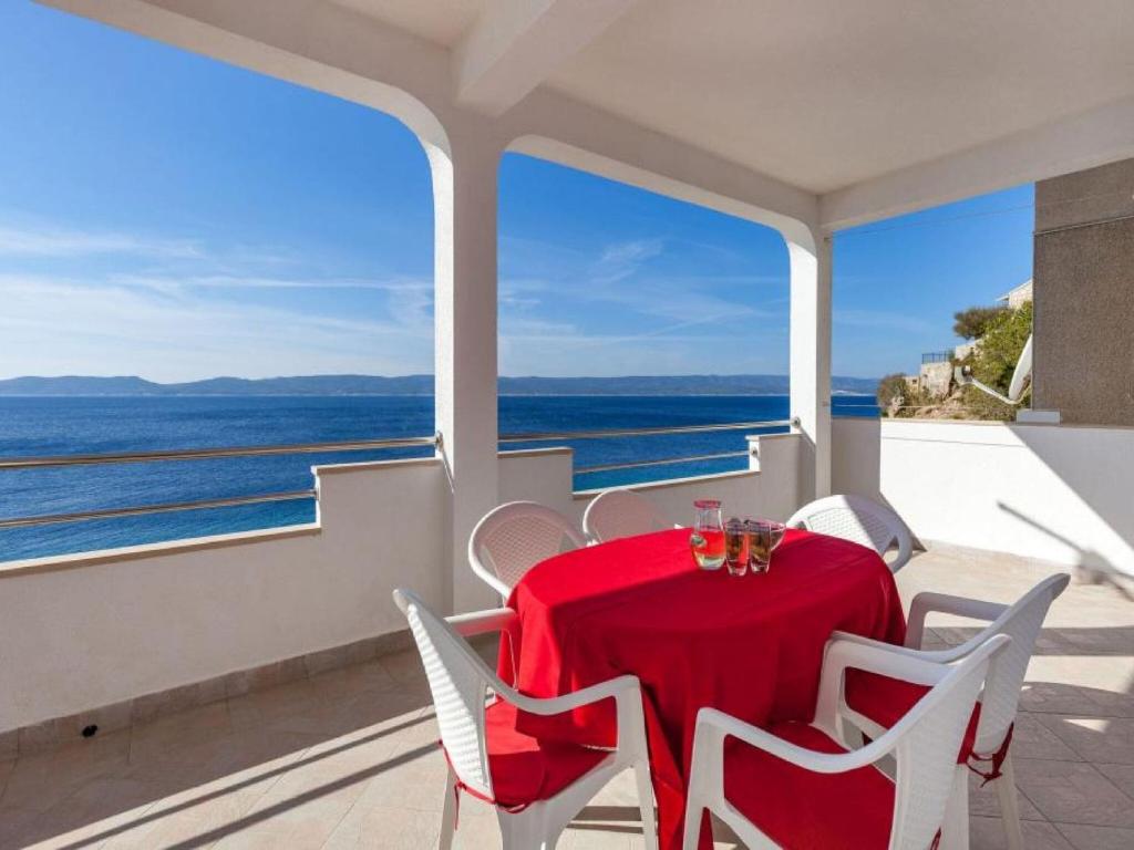 a table and chairs on a balcony with a view of the ocean at Apartments Nena ST - Two Bedroom Apartment with Terrace and Sea View A3 in Pisak
