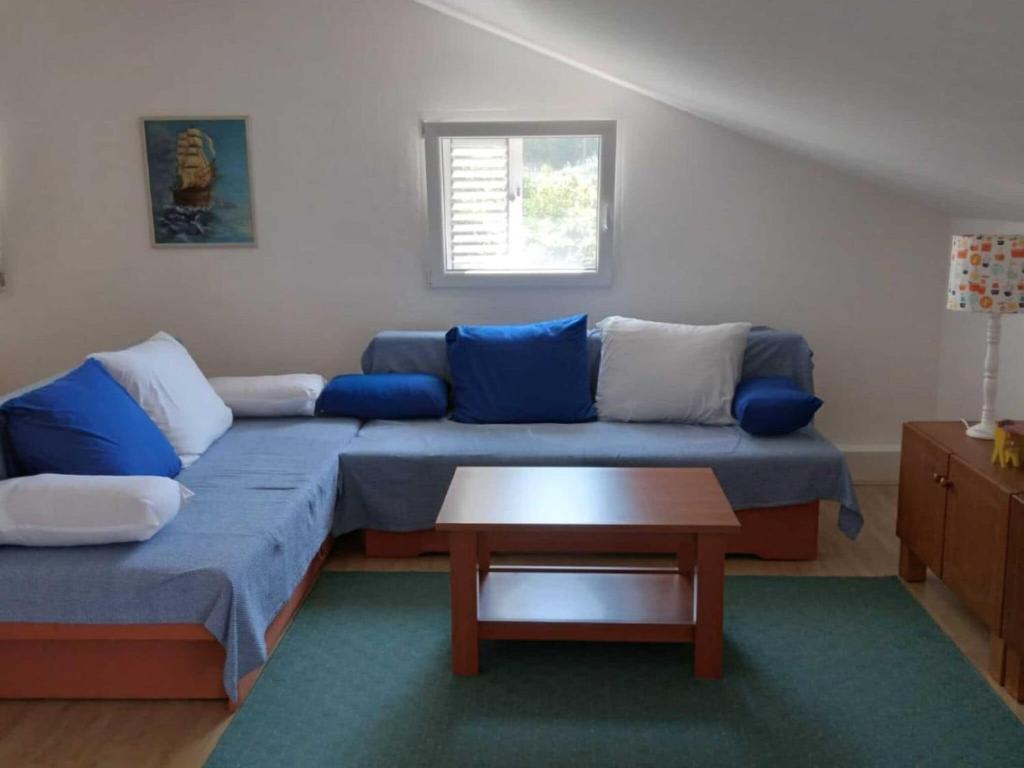 a living room with a blue couch and a table at Apartment Luna - One Bedroom Apartment with Terrace and Sea View Molunat in Molunat