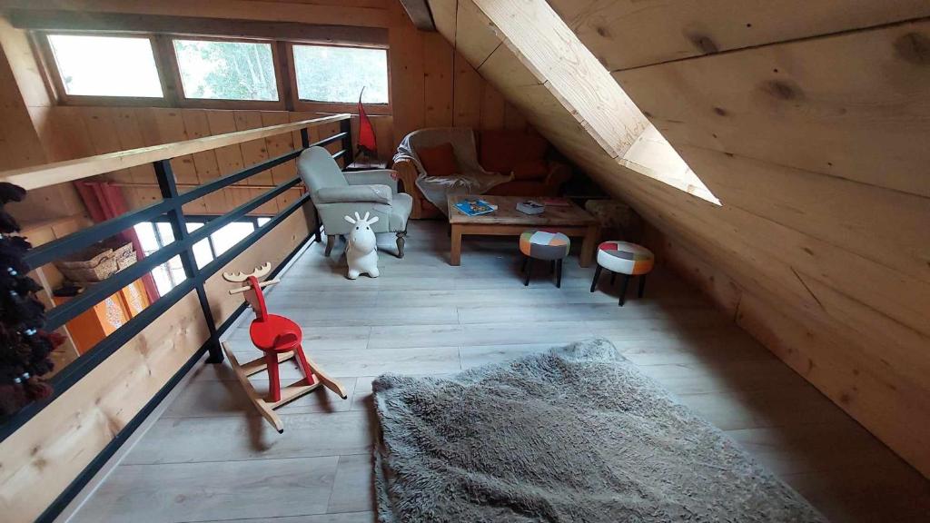a attic room with a couch and a chair at Yourtes Olachat proche Annecy in Faverges