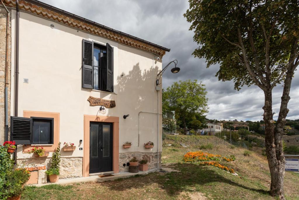 a white house with a door and a tree at Casa Vacanze Frattura in Frattura