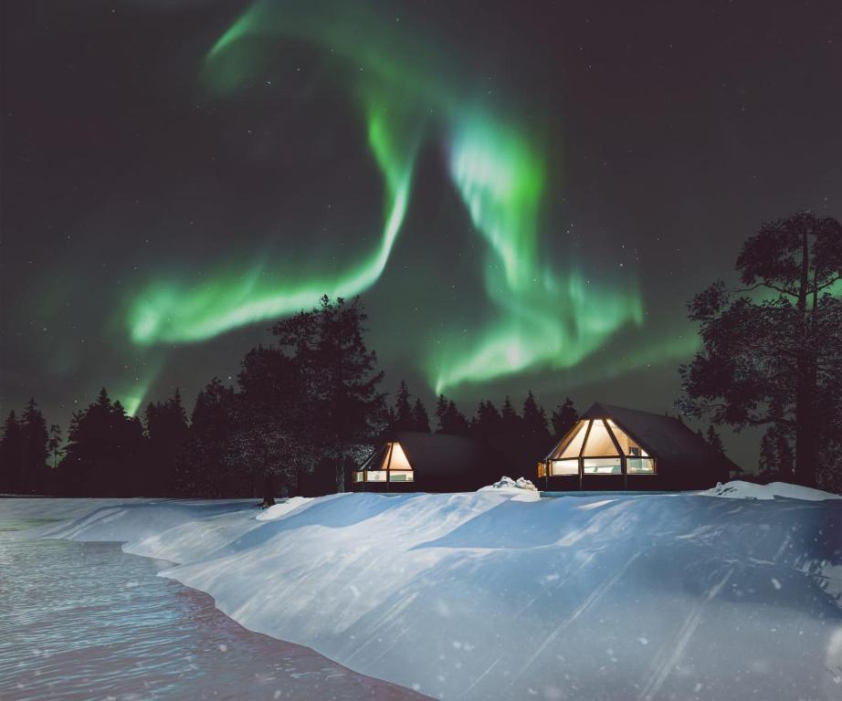 an image of the aurora in the sky over tents at Wilderness Hotel Nellim & Igloos in Inari