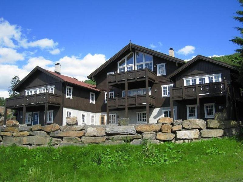 a large house with a stone fence in front of it at Ruud Tun in Hafjell