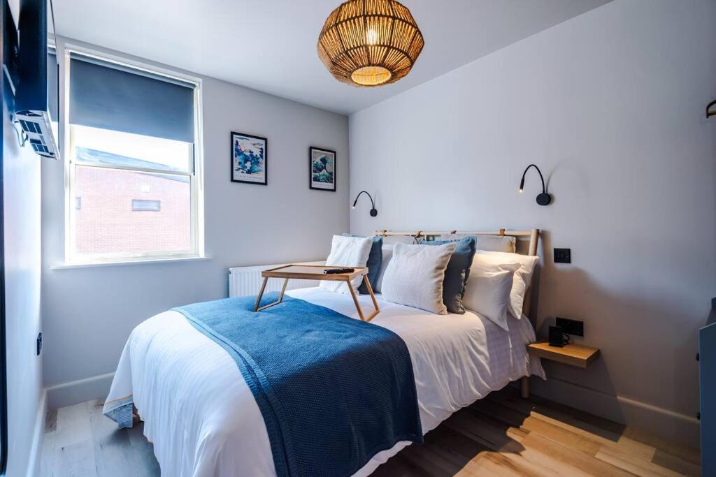 a bedroom with a bed with a table on it at Elegant 2B Retreat City Centre with Secure Parking in Chester