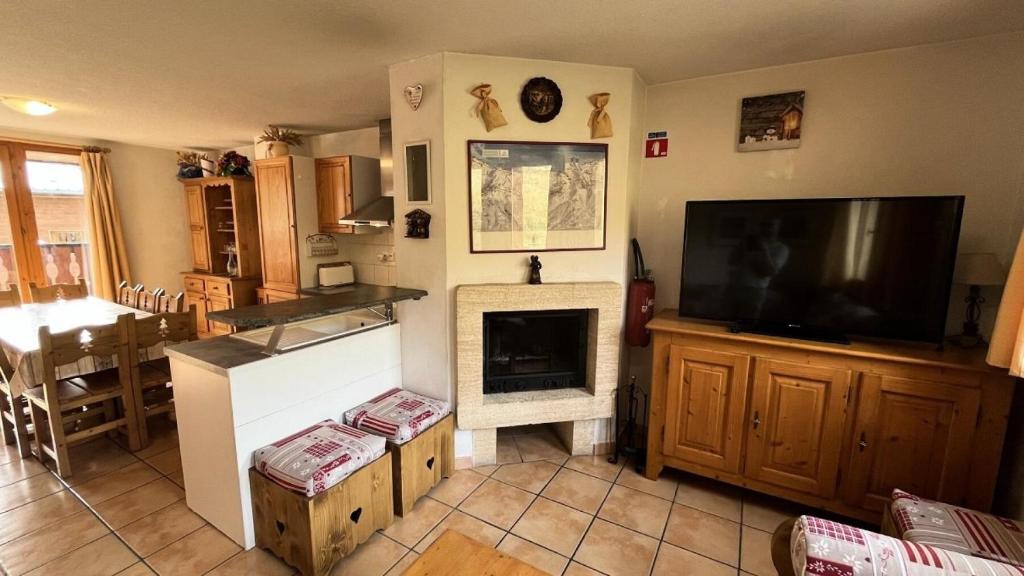 un salon avec une télévision et une cheminée dans l'établissement Résidence Les Alpages - Chalet des ALPAGES N°28 MAE-4711, à La Plagne Tarentaise