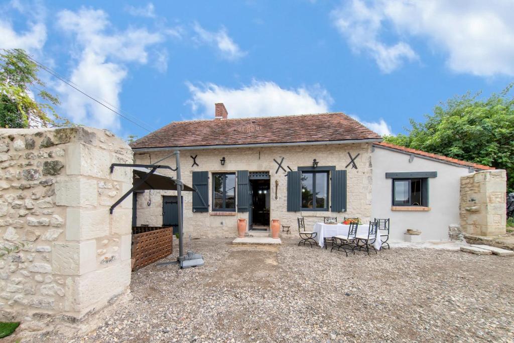 una piccola casa bianca con tavolo e sedie di Laureanna - Maison avec jardin de 1000 m2 a Descartes