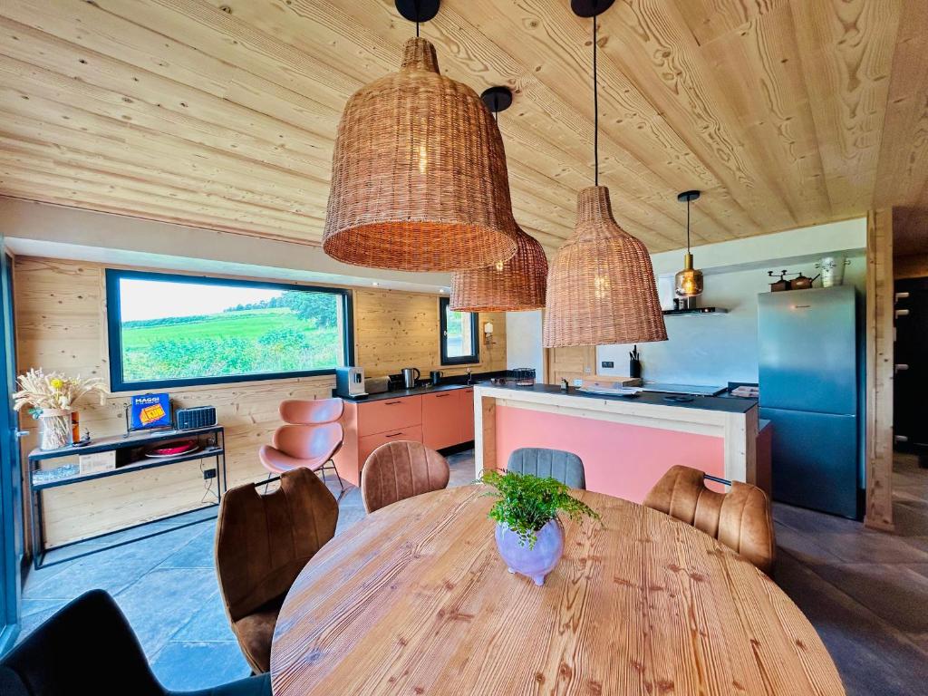 a dining room with a wooden table and a television at Chalet du Hazard in Gerbépal
