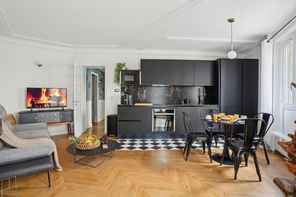 un salon avec une table et une cuisine dans l'établissement Magnifique appartement au cœur du XVIIIème, à Paris