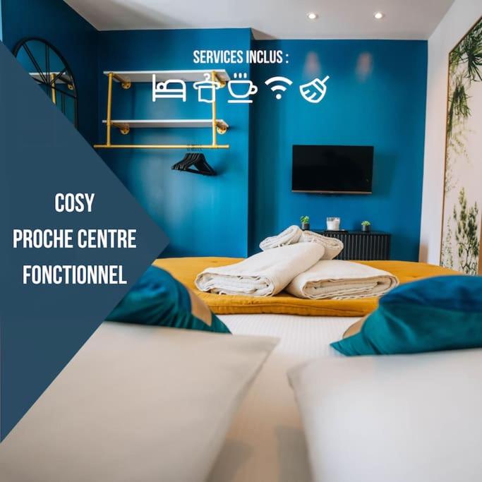 Cette chambre comprend 2 lits et un mur bleu. dans l'établissement Le Blue Bering - Confort & Design - Climatisation, à Châteauroux