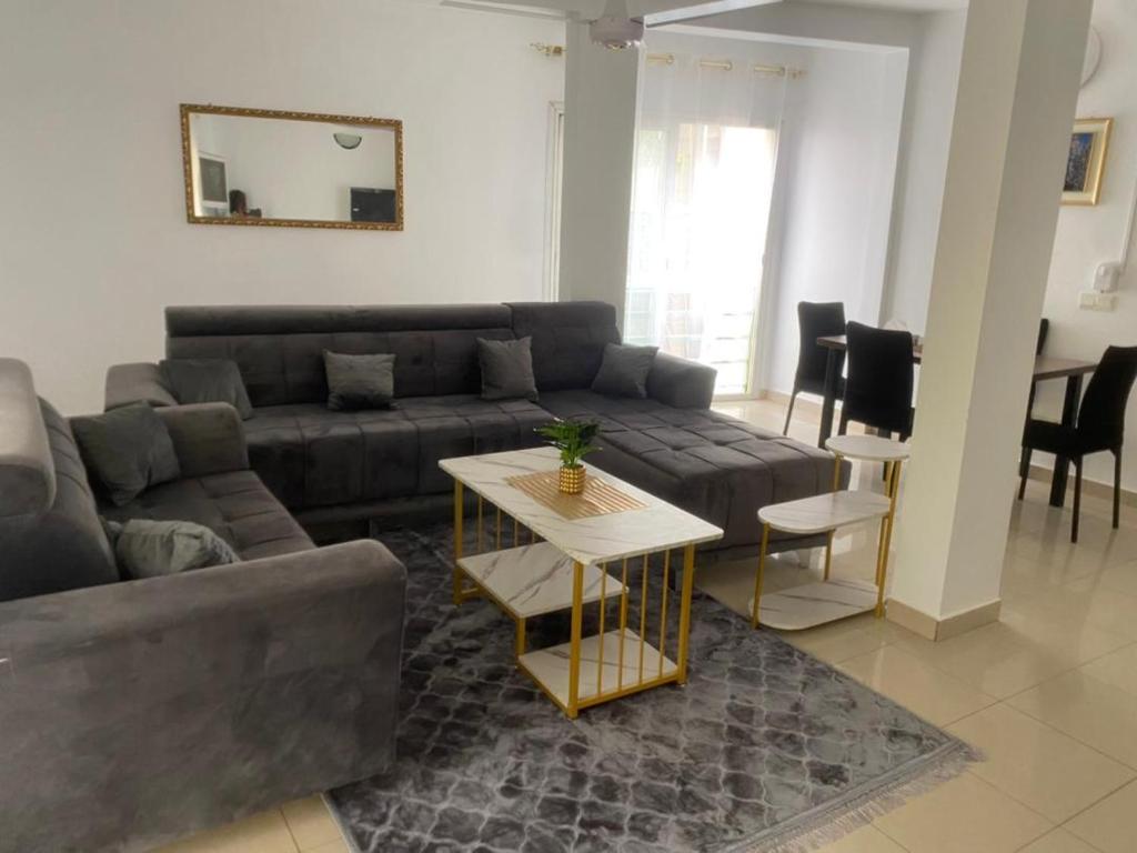 ein Wohnzimmer mit Sofa und Tisch in der Unterkunft Appartement meublé 3 chambres Cité Mixta in Grand Médina