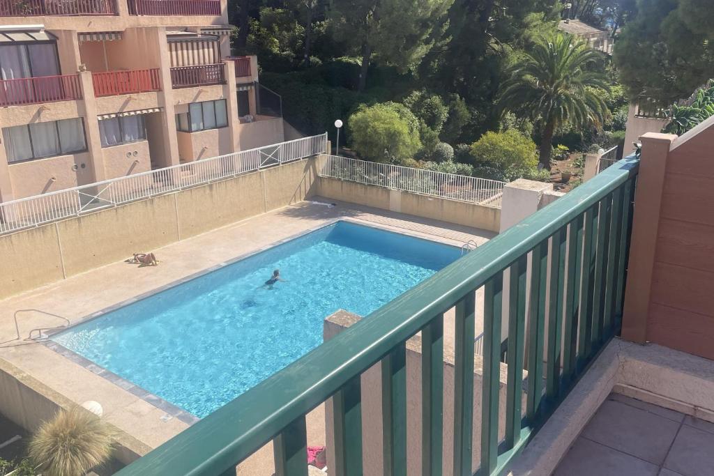 une personne se baignant dans une piscine sur un balcon dans l'établissement Bright flat with large terrace, à Bandol