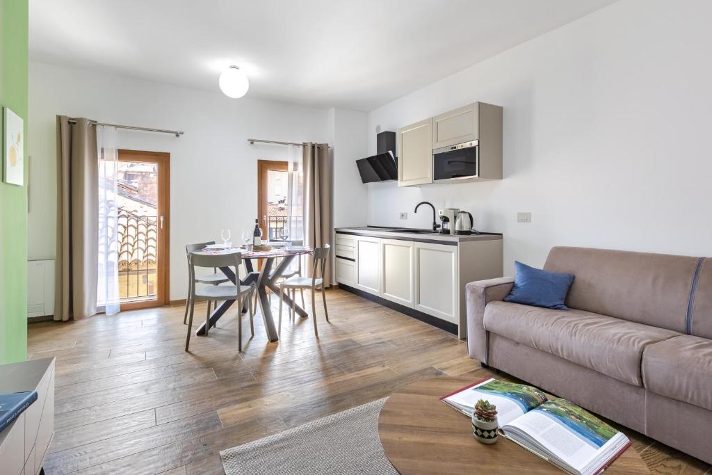 a living room with a couch and a table and a kitchen at Casa Matilla - Verde in La Morra