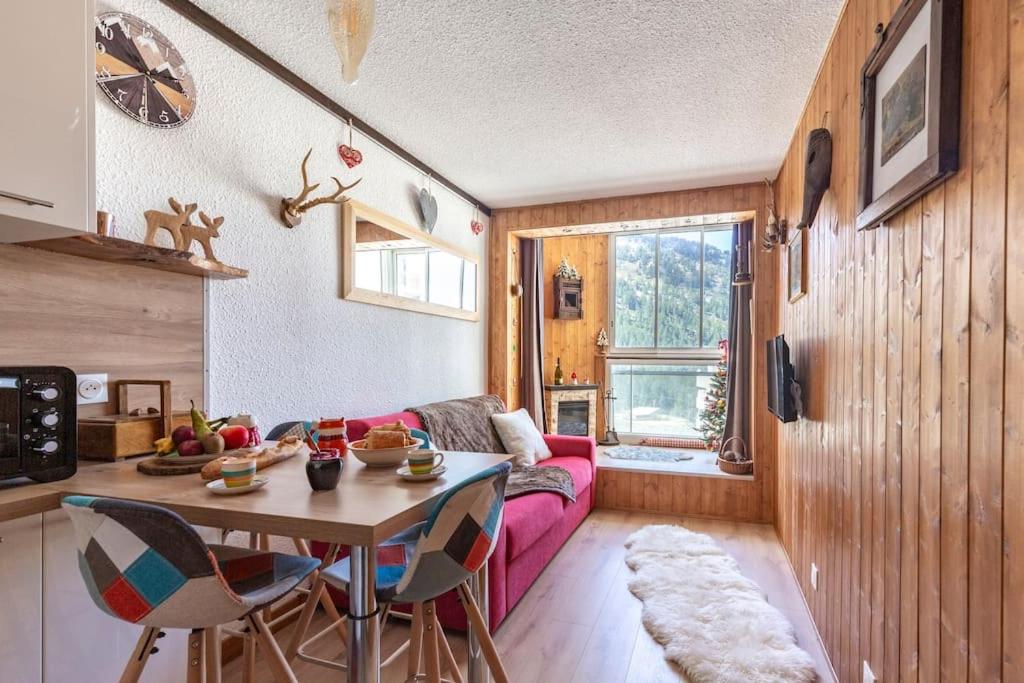 - un salon avec une table et un canapé rose dans l'établissement Chaleureux studio, wifi, local à ski, pieds pistes, à Isola 2000