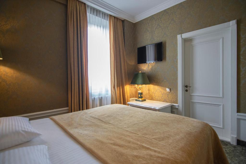 Postel nebo postele na pokoji v ubytování Royal Olympic Hotel