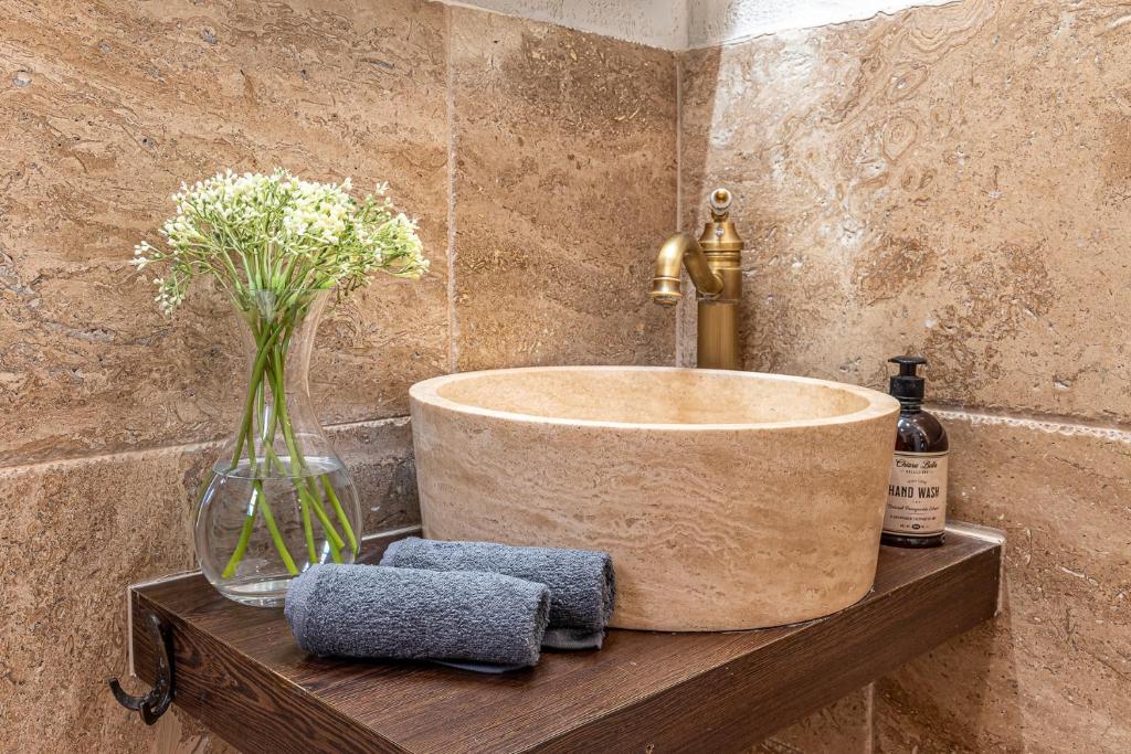 a bathroom with a sink and a vase of flowers at Апартаменти Стефани in Plovdiv