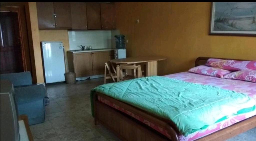 a bedroom with a bed and a kitchen with a refrigerator at Carita Lippo Kondominium in Carita