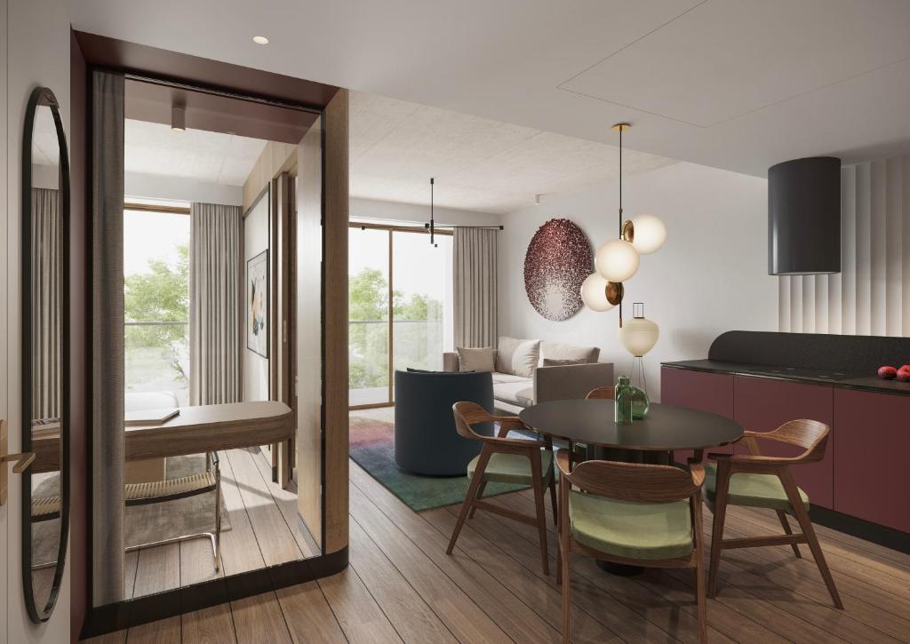 a kitchen and living room with a table and chairs at Baltic Park Loft by Zdrojowa in Świnoujście