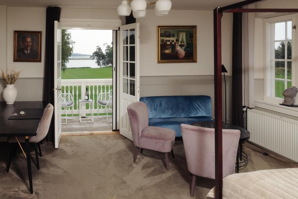 a bedroom with a bed and a desk and a chair at Gl. Avernæs Sinatur Hotel & Konference in Ebberup