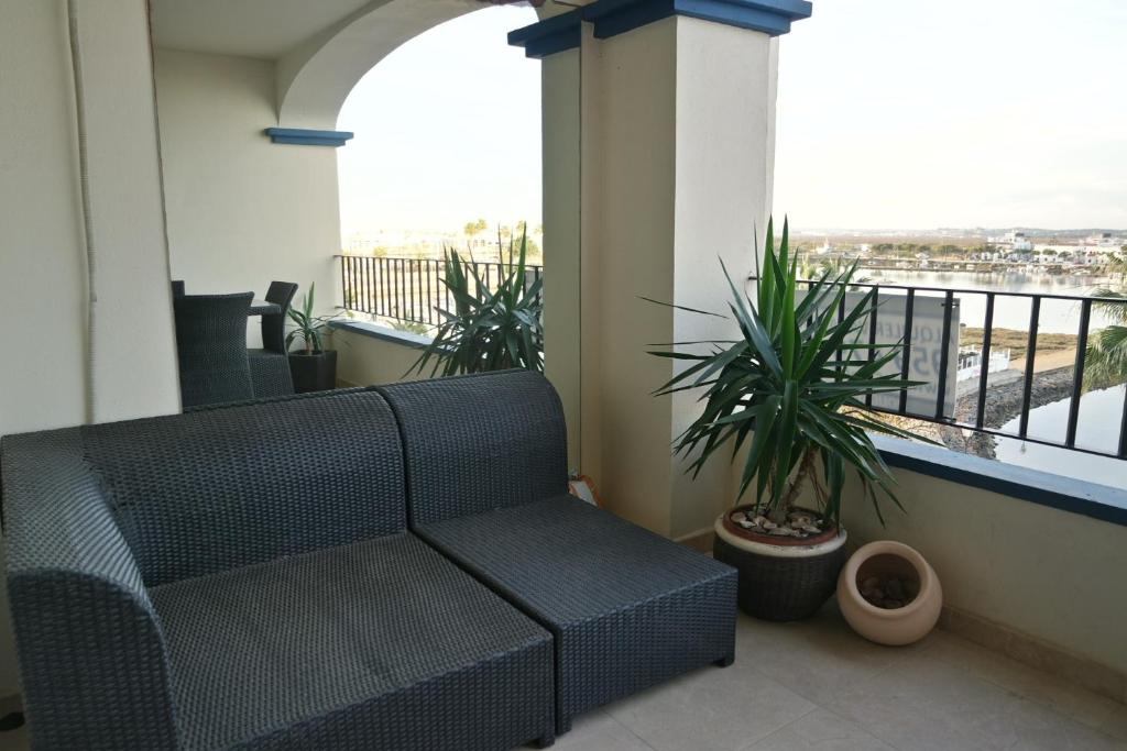eine schwarze Couch auf einem Balkon mit Pflanzen in der Unterkunft Marina I by Ĥ - Marina Isla Canela PMHI35P10 in Punta del moral