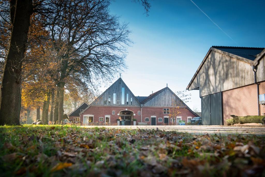 a large red brick building with two large barns at Erfgoed Bossem in Lattrop