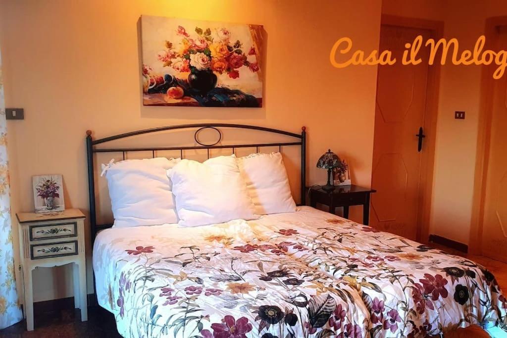 a bedroom with a bed and a painting on the wall at Casetta il Melograno Accogliente Bilocale al Mare in Villaggio Mosè