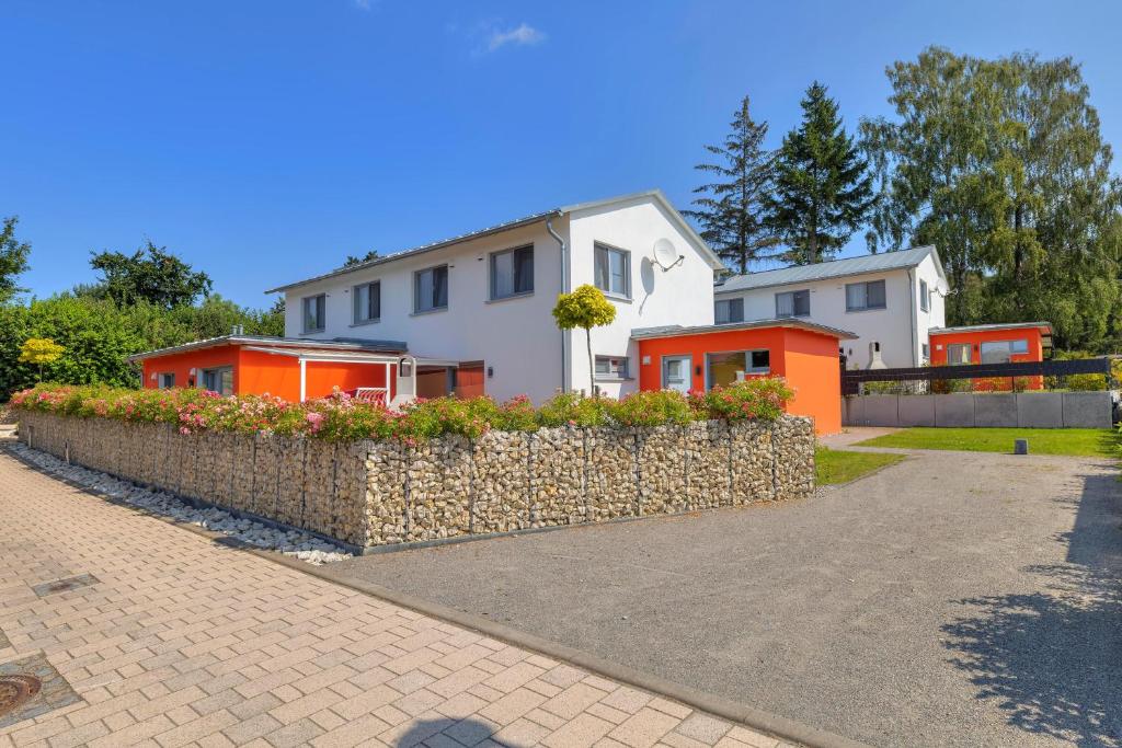 a house with a stone wall in front of a house at Ferienhaus 6 Schlafzimmer mit Sauna UnserUsedom Ostseebad Koserow Insel Usedom in Ostseebad Koserow