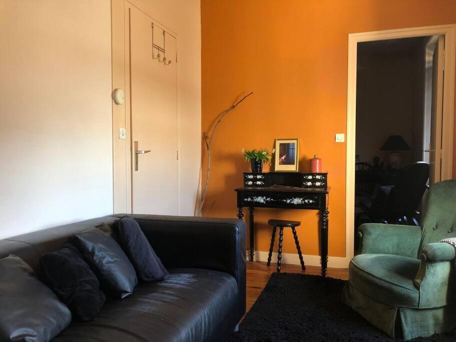 Una sala de estar con un sofá y un piano. en Le petit matelot, en Paimpol