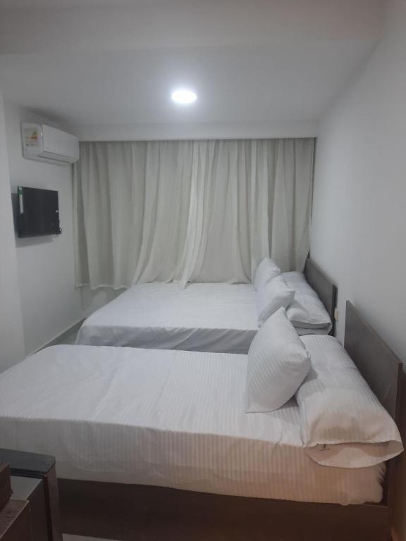 a bedroom with two beds with white sheets and pillows at villa 17 in Cairo