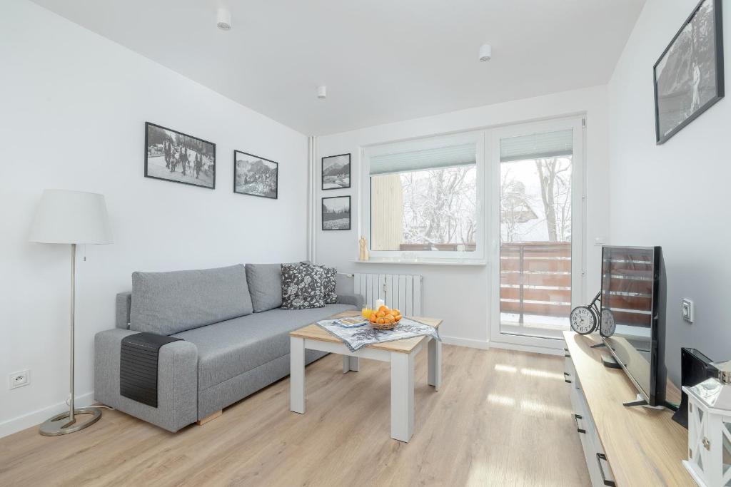 a living room with a couch and a table at Mountain Corner Apartment in Zakopane by Noclegi Renters in Zakopane