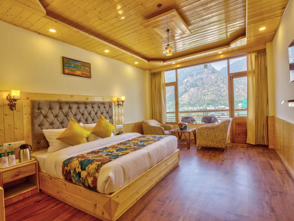 a bedroom with a large bed and a table at Swastik Grand Manali in Manāli