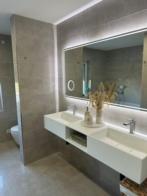 a bathroom with a sink and a mirror at Luxury Apartment Marz in Schwanau