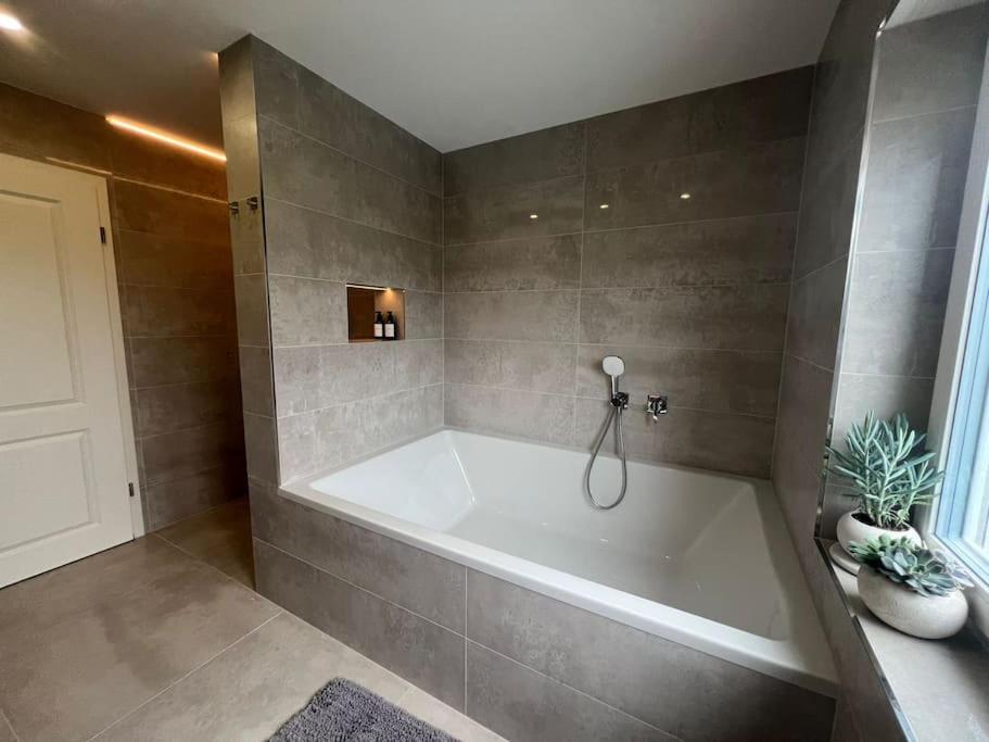 a bathroom with a large white tub in a room at Luxury Apartment Marz in Schwanau