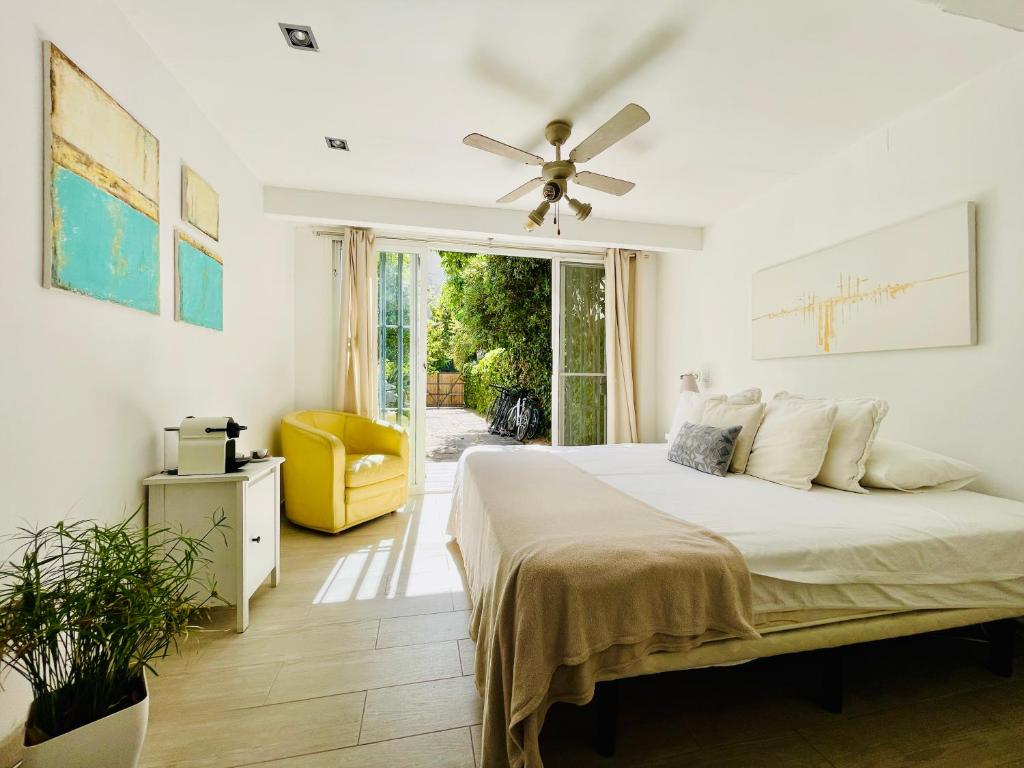 a bedroom with a bed and a ceiling fan at SuperHosts Suites Estepona in Estepona