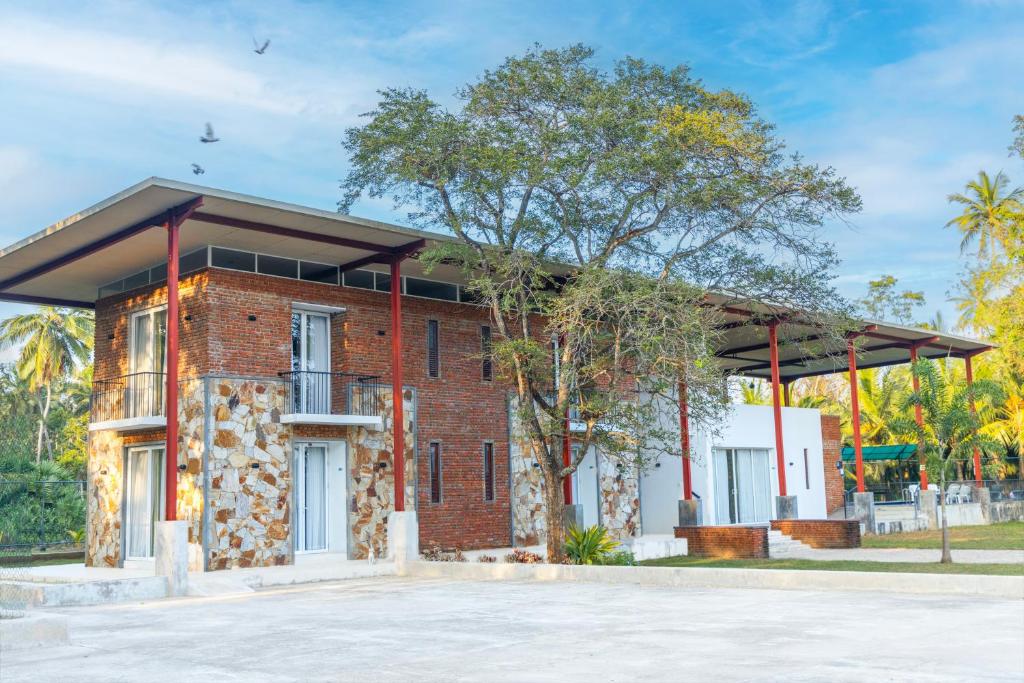 ein rotes Backsteingebäude mit einem Dach in der Unterkunft Hungili Farm & Eco Resort in Maho