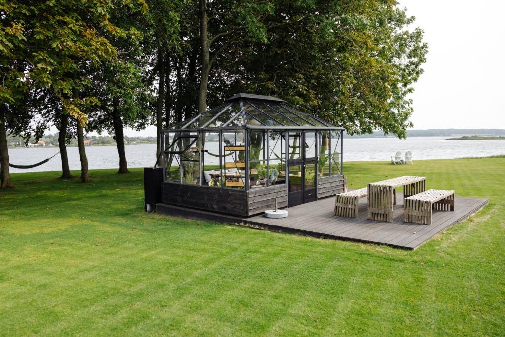 a gazebo with benches on a grass field at Gl. Avernæs Sinatur Hotel & Konference in Ebberup