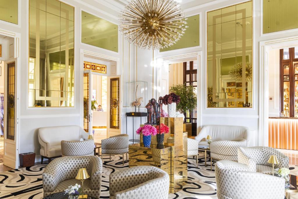 a lobby with chairs and a chandelier at Grand Hotel Principe Di Piemonte in Viareggio