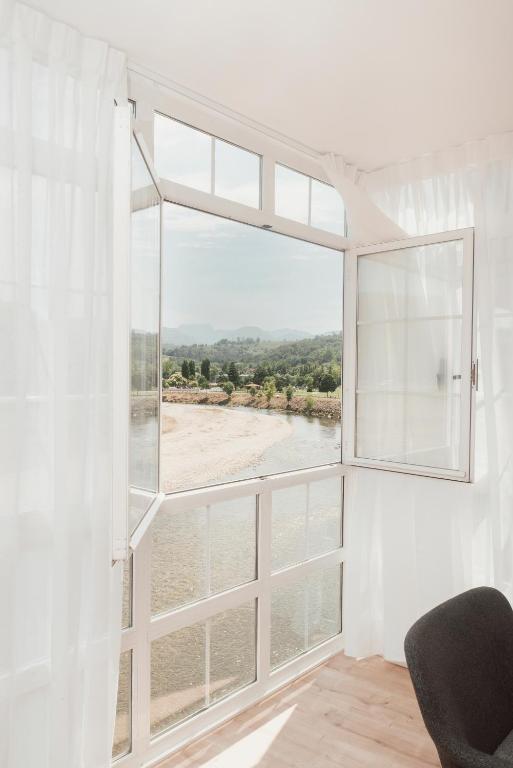 a room with a large window with a view of the water at Mirando al sella in Arriondas