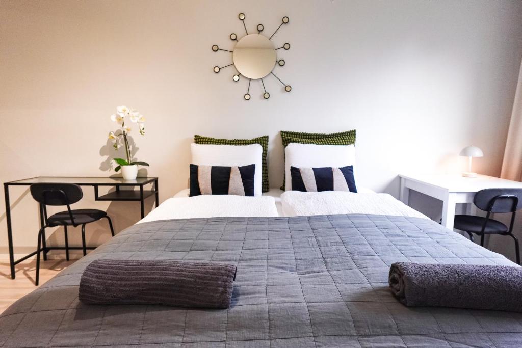 a bedroom with a bed and two tables and a mirror at Family Retreat Near Train and Kuusijärvi Lake in Vantaa