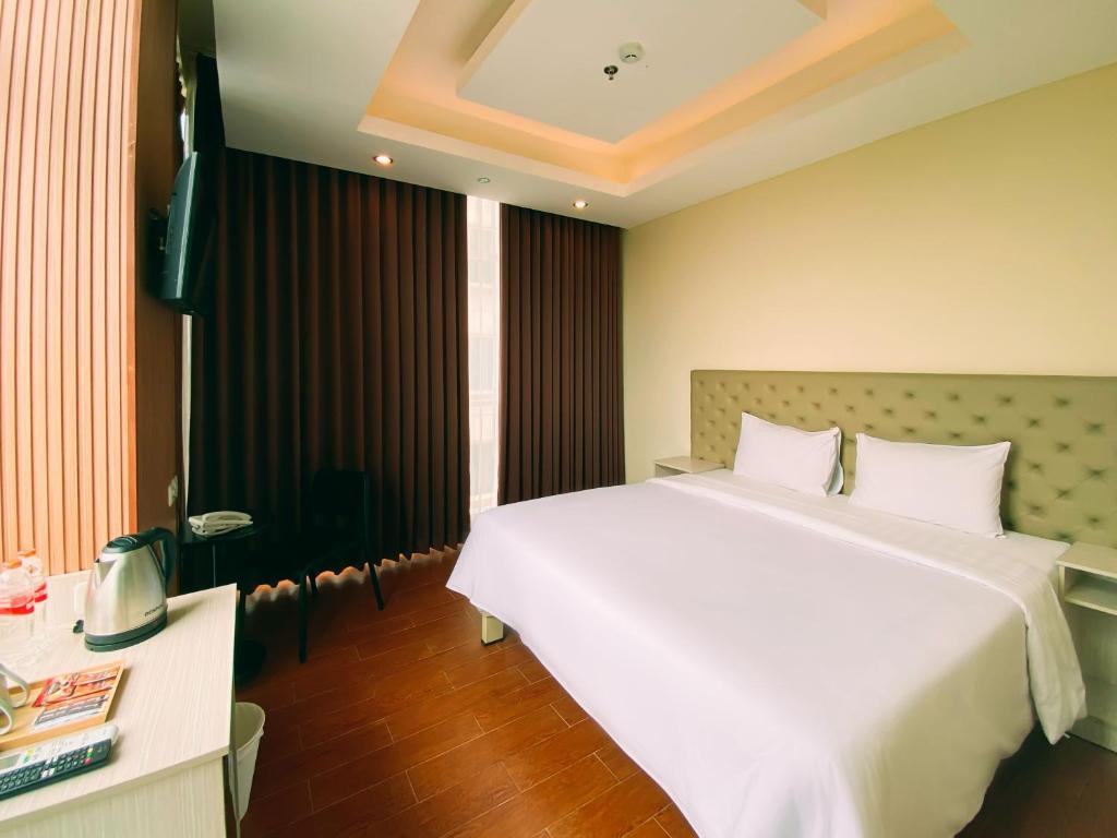 Postel nebo postele na pokoji v ubytování Tebu Hotel Bandung