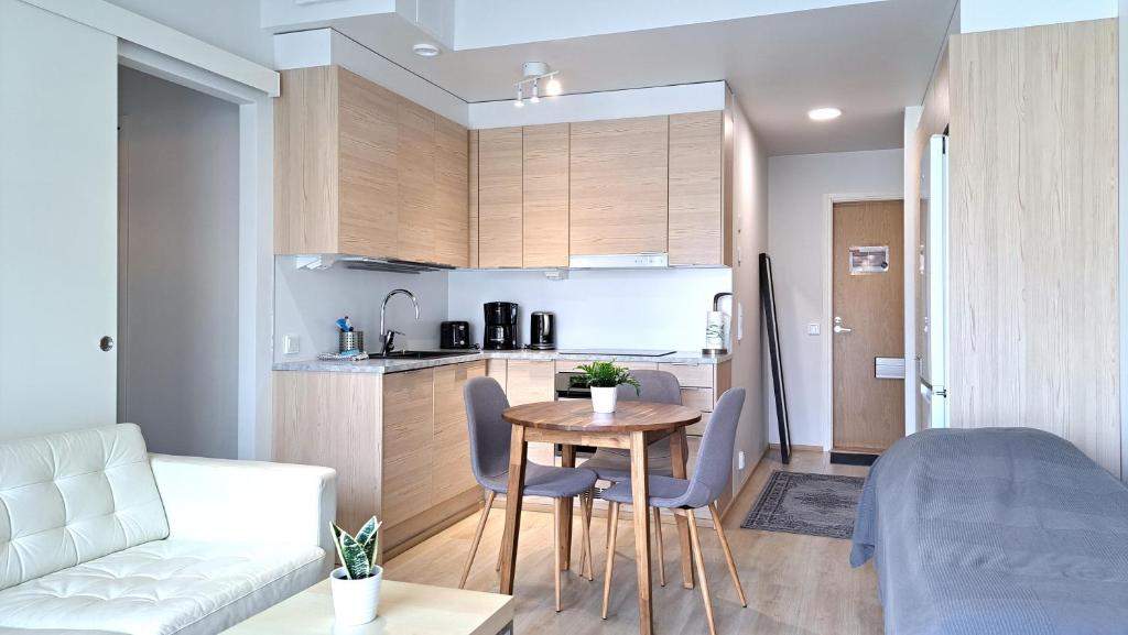 タンペレにあるKotimaailma Apartments - Parvekkeellinen keskustakaksio - Aleksanterinkatuのテーブルとキッチンのあるリビングルーム