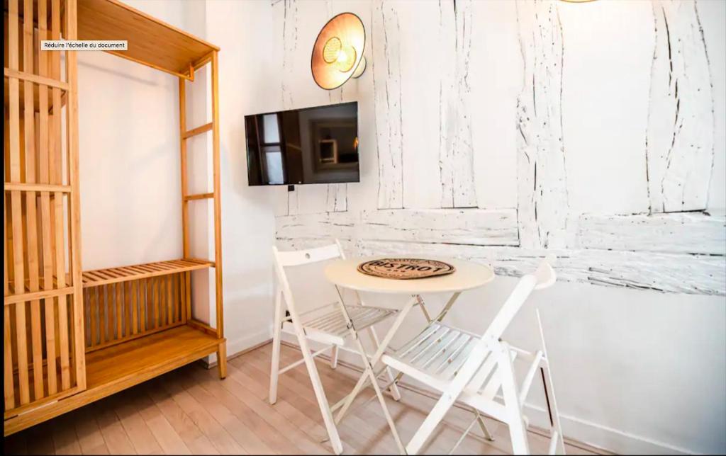 - une petite table et des chaises blanches dans la chambre dans l'établissement Appartement pour 2 personnes, à Paris