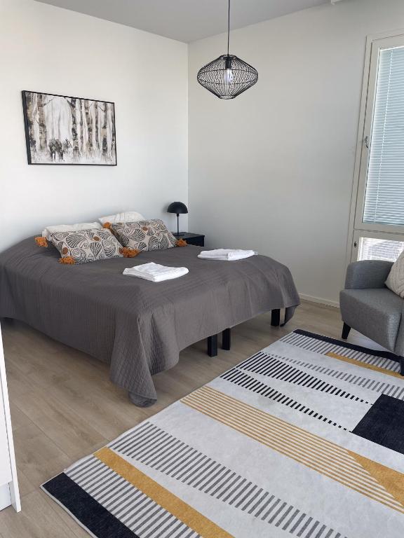 a bedroom with a bed and a couch and a chair at Snowflake Suites VII in Rovaniemi