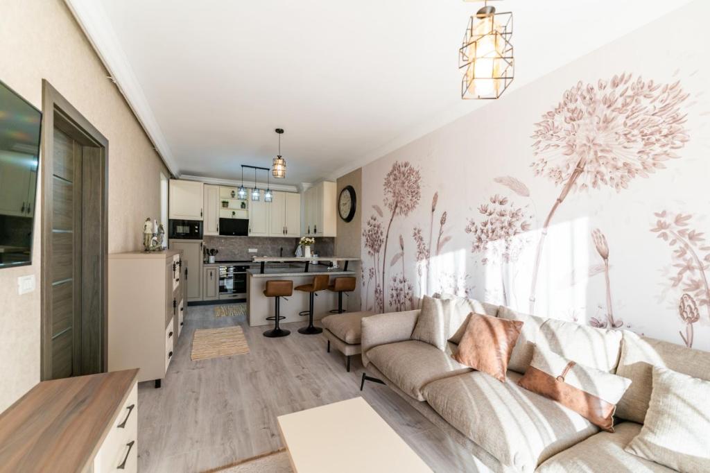 a living room with a couch and a kitchen at Luxury Cozy Apartments at Adora Park in Arad
