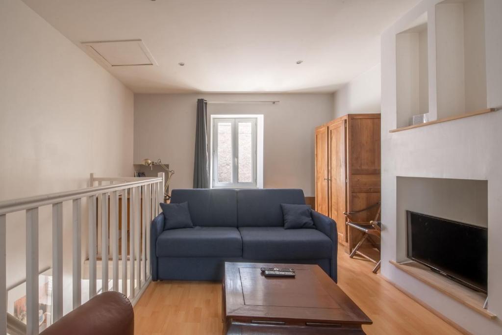 un salon avec un canapé bleu et une cheminée dans l'établissement Maison mitoyenne- 4 pers - Centre historique de Pornic, à Pornic