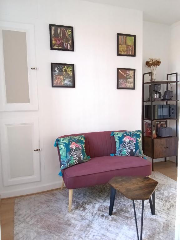 un salon avec un canapé violet et une table dans l'établissement Appartement au cœur du patrimoine sézannais, à Sézanne
