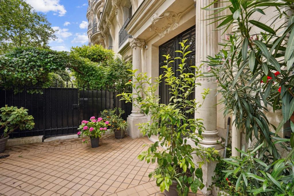 une cour d'une maison ornée de plantes et de fleurs dans l'établissement Appart haussmannien, à Paris